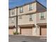 Three-story townhome with two car garage and neutral stucco, roof and doors at 538 Ylang Pl, Henderson, NV 89015