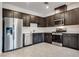 Modern kitchen features stainless steel appliances, dark wood cabinetry, and tile flooring at 538 Ylang Pl, Henderson, NV 89015