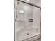 Modern tiled shower featuring built-in seating, a rainfall shower head, and a sliding glass door at 538 Ylang Pl, Henderson, NV 89015