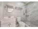 Bathroom with a round mirror, a toilet, and a tiled shower at 5516 Cory Pl, Las Vegas, NV 89107
