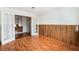 Bedroom with decorative paneled walls features wood-look flooring and double doors at 5516 Cory Pl, Las Vegas, NV 89107