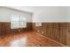 Bedroom with decorative paneled walls features wood-look flooring and natural light from the window at 5516 Cory Pl, Las Vegas, NV 89107