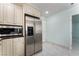 Modern kitchen featuring stainless steel refrigerator and microwave, complemented by cream-colored cabinetry at 5516 Cory Pl, Las Vegas, NV 89107
