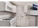 An efficient kitchen featuring white cabinets, countertops, and a gas range stove at 5516 Cory Pl, Las Vegas, NV 89107
