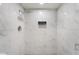 Elegant shower with marbled tiles, recessed shelving, and rainfall shower head at 5516 Cory Pl, Las Vegas, NV 89107