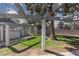 Exterior common area with lush green grass, a pergola-shaded walkway, and mature trees at 5523 Orchard Ln # 0, Las Vegas, NV 89110