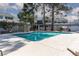Community pool with clear blue water, surrounded by a concrete patio and fencing, near mature trees at 5523 Orchard Ln # 0, Las Vegas, NV 89110