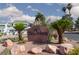 Stone entrance sign to The Arbors community with well-maintained landscaping and palm trees under a partly cloudy sky at 5523 Orchard Ln # 0, Las Vegas, NV 89110
