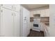 Efficient kitchen with white appliances, ample cabinet space, and durable laminate flooring for easy maintenance at 5523 Orchard Ln # 0, Las Vegas, NV 89110