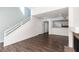 Open-concept living room with laminate floors, a staircase, and a view into the adjoining kitchen at 5523 Orchard Ln # 0, Las Vegas, NV 89110