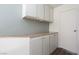 Ample storage space with white cabinets, countertop, and a convenient door at 5523 Orchard Ln # 0, Las Vegas, NV 89110
