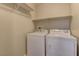 Bright laundry room with white washer and dryer, and built-in shelf at 5552 Dueces Wild Ct # 101, Las Vegas, NV 89122