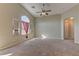 Spacious living room with arched windows, ceiling fan, and neutral color palette at 5552 Dueces Wild Ct # 101, Las Vegas, NV 89122