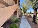 Exterior view showcases the building's architectural details, walkway, and manicured landscaping at 5750 E Hacienda Ave # 107, Las Vegas, NV 89122