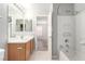 Bathroom featuring wood vanity, large mirror, and shower-tub combo at 6308 Anticline Ave, Las Vegas, NV 89139