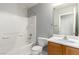 Well-lit bathroom with a shower-tub combo, white tile, and a wood vanity with a framed mirror at 6308 Anticline Ave, Las Vegas, NV 89139