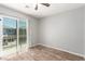 This bedroom has wood-look floors, a ceiling fan, and a balcony at 6308 Anticline Ave, Las Vegas, NV 89139