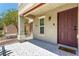 Inviting front porch with decorative tile flooring and wrought iron railing and burgundy door at 6308 Anticline Ave, Las Vegas, NV 89139