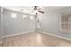 Spacious main bedroom with light grey walls, wood-look tile flooring, and a ceiling fan at 6308 Anticline Ave, Las Vegas, NV 89139
