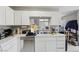 Bright kitchen with white cabinets and an eat-in breakfast area, featuring a dishwasher and sink at 6812 Coral Rock Dr, Las Vegas, NV 89108