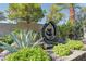 Close-up of backyard landscaping with a decorative water feature surrounded by lush greenery at 6845 Hidden Sunset Ln, Las Vegas, NV 89120