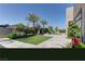 Spacious backyard featuring a well-manicured lawn, elegant landscaping, and mature palm trees at 6845 Hidden Sunset Ln, Las Vegas, NV 89120
