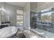 Modern bathroom with a glass-enclosed shower and separate soaking tub with marble accents at 6845 Hidden Sunset Ln, Las Vegas, NV 89120
