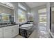 Elegant bathroom featuring a soaking tub with dark marble surround and dual vanity sinks at 6845 Hidden Sunset Ln, Las Vegas, NV 89120