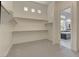 Walk-in closet with ample shelving, carpeted floor, and access to an en-suite bathroom at 6845 Hidden Sunset Ln, Las Vegas, NV 89120