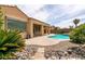 Backyard oasis featuring a pool, covered patio, and low-maintenance desert landscaping, perfect for outdoor relaxation at 6929 Homing Pigeon Pl, North Las Vegas, NV 89084