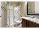 Bathroom featuring a glass-enclosed shower, granite countertop vanity, and neutral tiling, offering a clean, modern space at 6929 Homing Pigeon Pl, North Las Vegas, NV 89084