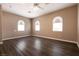 Spacious bedroom featuring arched windows, ceiling fan, and wood-look floors, providing a comfortable living space at 6929 Homing Pigeon Pl, North Las Vegas, NV 89084