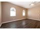 Bright bedroom with arched windows and wood-look flooring offering plenty of natural light and comfortable living space at 6929 Homing Pigeon Pl, North Las Vegas, NV 89084