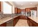 Modern kitchen featuring dark wood cabinets, granite counters, and stainless steel appliances at 6929 Homing Pigeon Pl, North Las Vegas, NV 89084