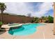 Backyard with a kidney-shaped pool, integrated spa and desert landscaping at 6929 Homing Pigeon Pl, North Las Vegas, NV 89084