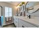 Well-lit bathroom with double vanity, modern fixtures, and stylish round mirrors at 7077 Sunland Hills Ave, Las Vegas, NV 89113