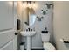 Charming powder room featuring a pedestal sink, decorative mirror, and modern fixtures at 7077 Sunland Hills Ave, Las Vegas, NV 89113