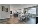 Bright, modern kitchen with white cabinets, large island, and adjacent dining area with seating for eight at 7077 Sunland Hills Ave, Las Vegas, NV 89113