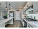 Modern kitchen with stainless appliances, light countertops, gas cooktop, and stylish pendant lighting at 7077 Sunland Hills Ave, Las Vegas, NV 89113