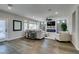 Spacious living room with an electric fireplace, large window, and wood flooring at 7077 Sunland Hills Ave, Las Vegas, NV 89113