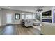 Spacious living room with an electric fireplace, large window, and wood flooring at 7077 Sunland Hills Ave, Las Vegas, NV 89113