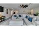 Comfortable living room showcasing a large sectional sofa, carpet and fan at 7077 Sunland Hills Ave, Las Vegas, NV 89113