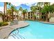 Community swimming pool with lounge chairs, landscaping, and palm trees at 7143 S Durango Dr # 202, Las Vegas, NV 89113