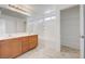 Bright bathroom with double sinks, wood cabinets, shower-tub, and a walk-in closet with white shelving at 7464 Edgecove Ct, Las Vegas, NV 89139