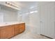 Bathroom featuring double sinks, wood cabinetry, shower-tub combination, and white paneled door at 7464 Edgecove Ct, Las Vegas, NV 89139
