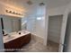Bathroom featuring double sinks, shower over tub and closet with shelving at 7464 Edgecove Ct, Las Vegas, NV 89139