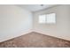This bedroom features neutral carpeting and a window that lets in natural light at 7464 Edgecove Ct, Las Vegas, NV 89139