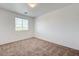 This bedroom features neutral carpeting and a window that lets in natural light at 7464 Edgecove Ct, Las Vegas, NV 89139