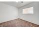 Minimalist bedroom featuring neutral carpet, white walls, and window providing natural light at 7464 Edgecove Ct, Las Vegas, NV 89139