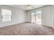 Bright, carpeted bedroom with natural light, a ceiling fan, and sliding glass doors leading to the private backyard at 7464 Edgecove Ct, Las Vegas, NV 89139